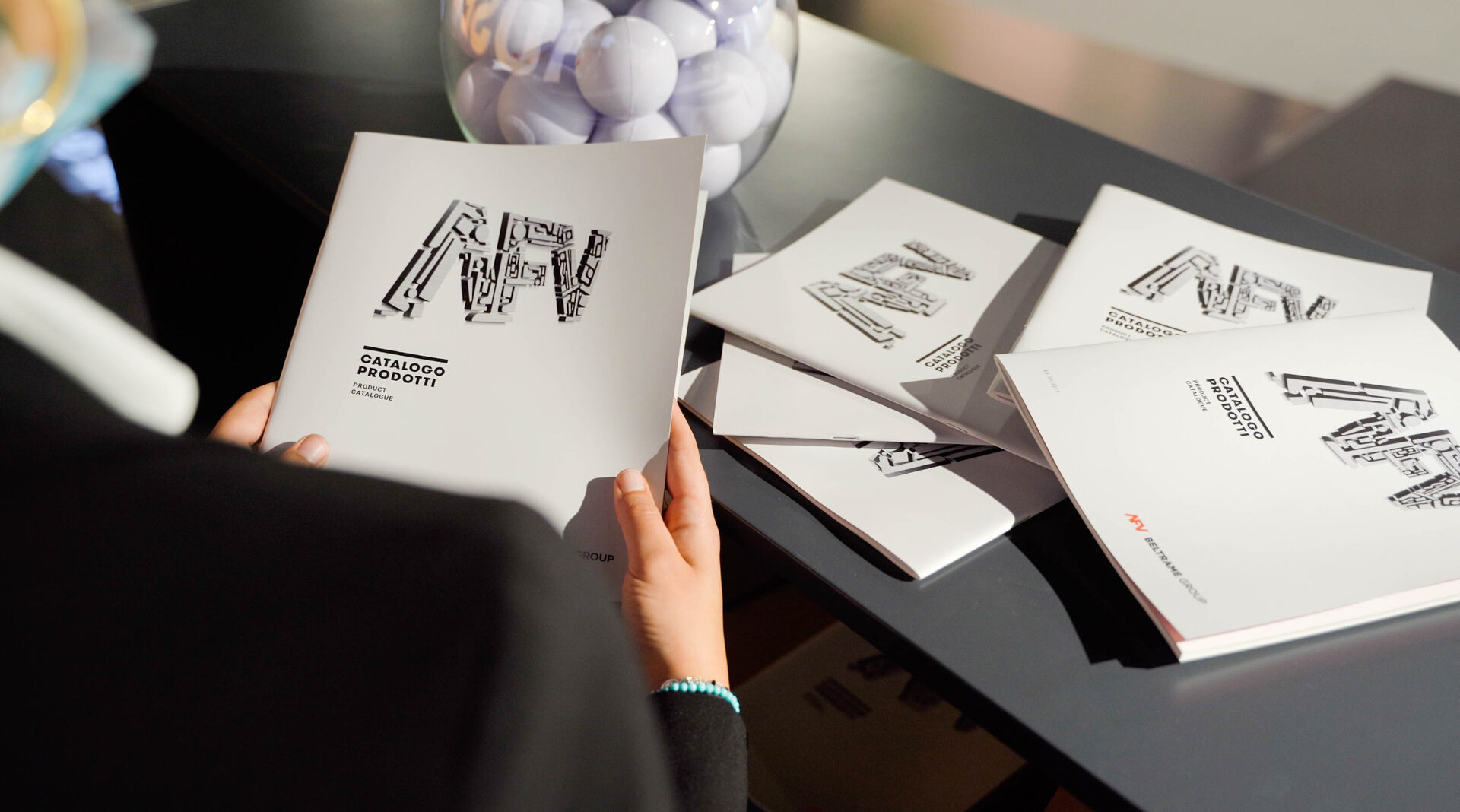 Stand di AFV Beltrame a fiera MIS 2021 - settore acciaierie, persone che guarda catalogo prodotti